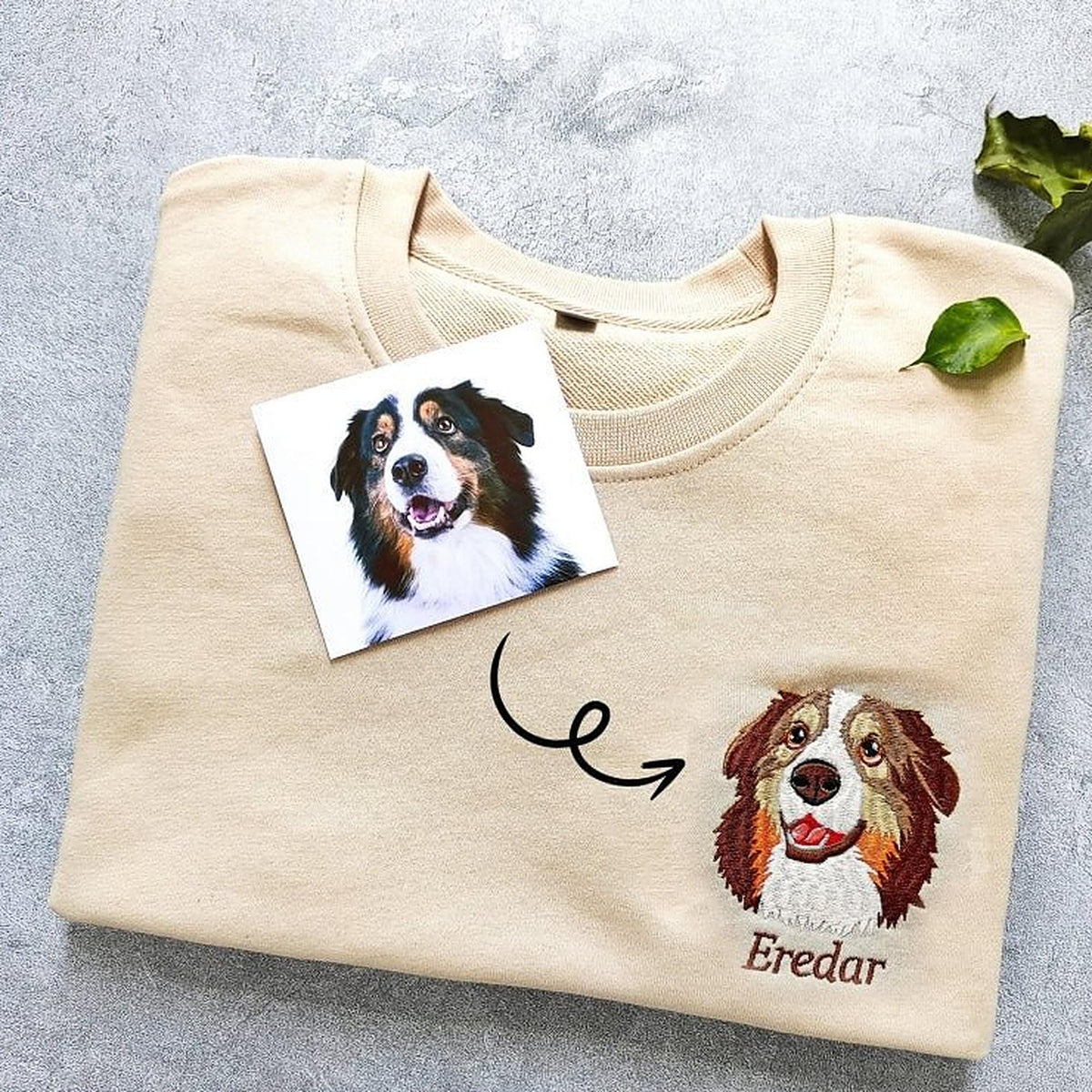 La photo d’un chien posée sur un sweat beige, à côté de son portrait brodé
