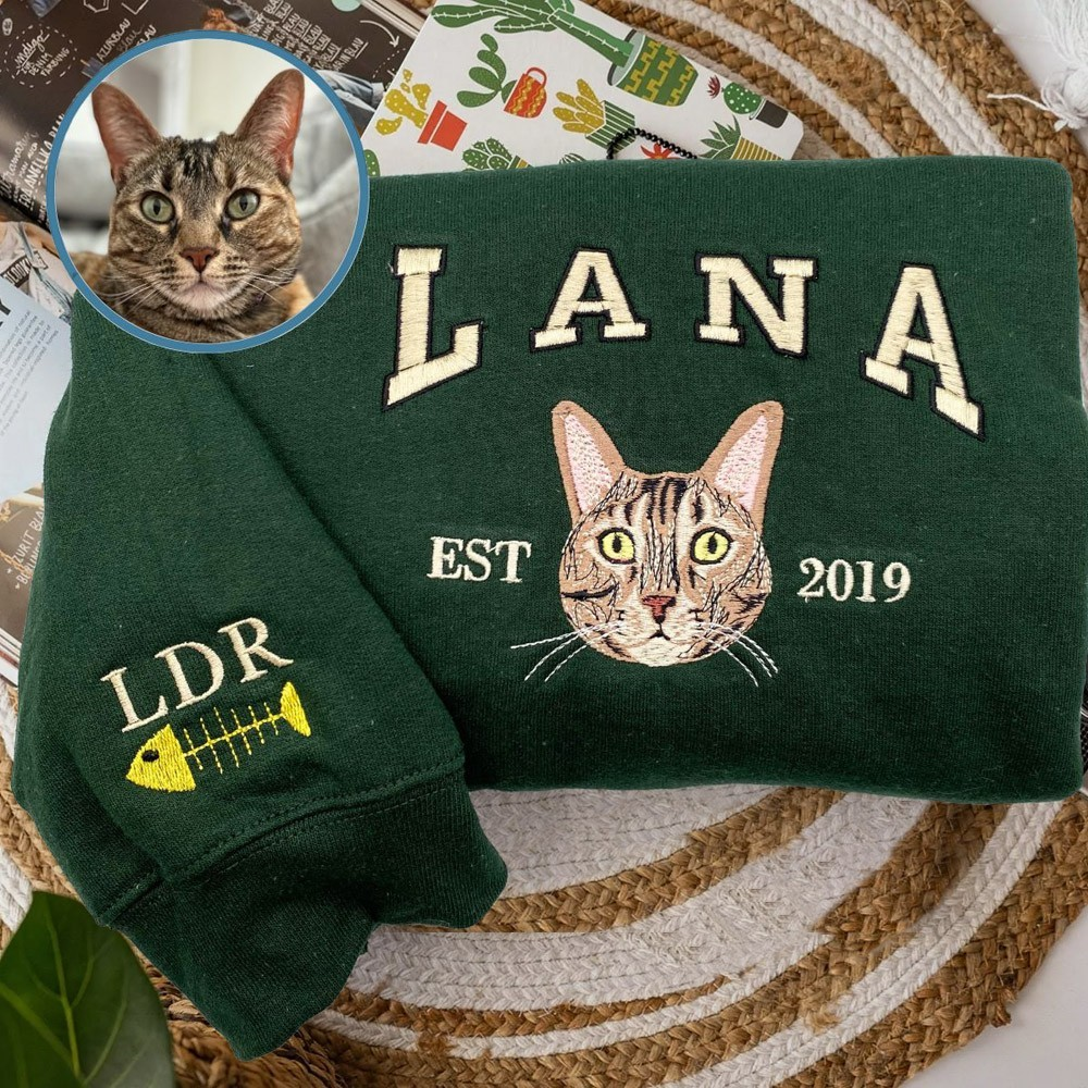 Sweat vert brodé du portrait d'un chat avec prénom et année, exemple réalisé par notre atelier partenaire